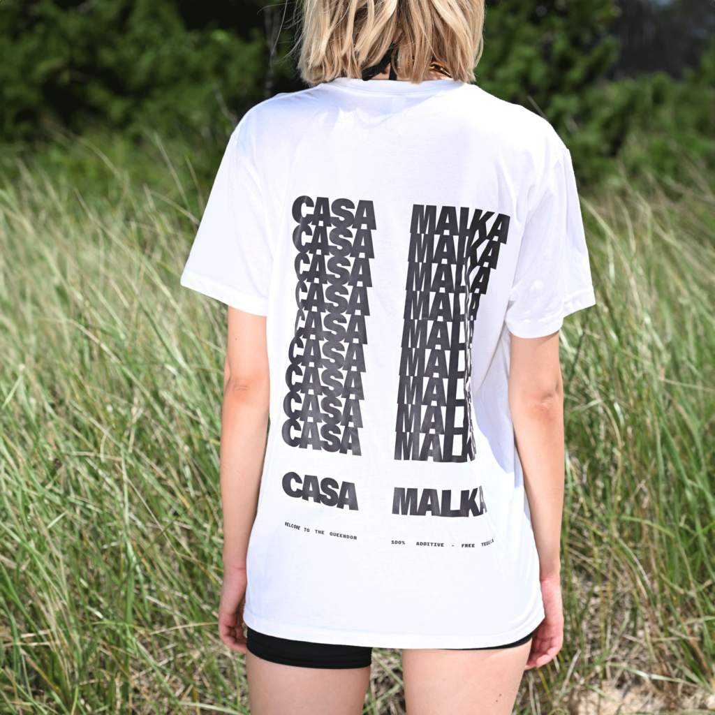 Back view of woman wearing Casa Malka white t-shirt with bold back design
