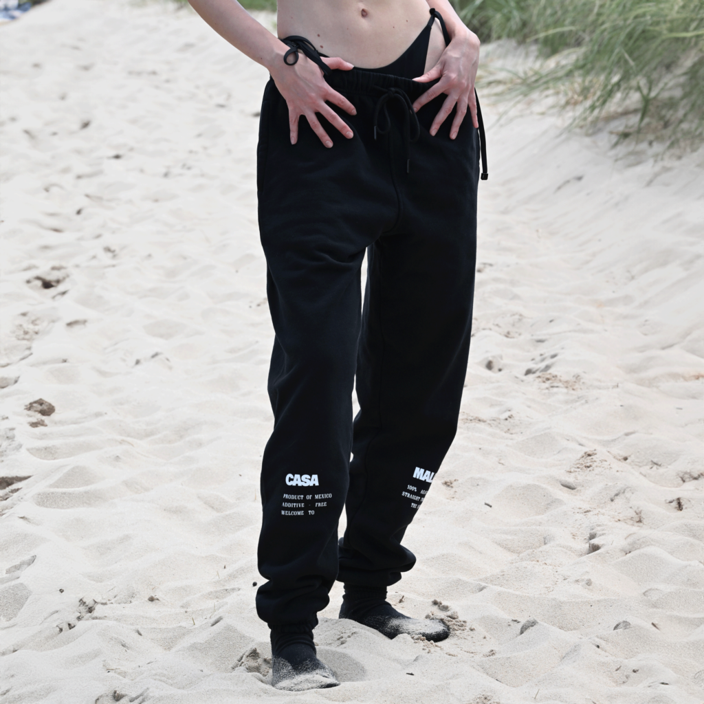 Close-up of black Casa Malka joggers with hand in pocket, showing detailed design
