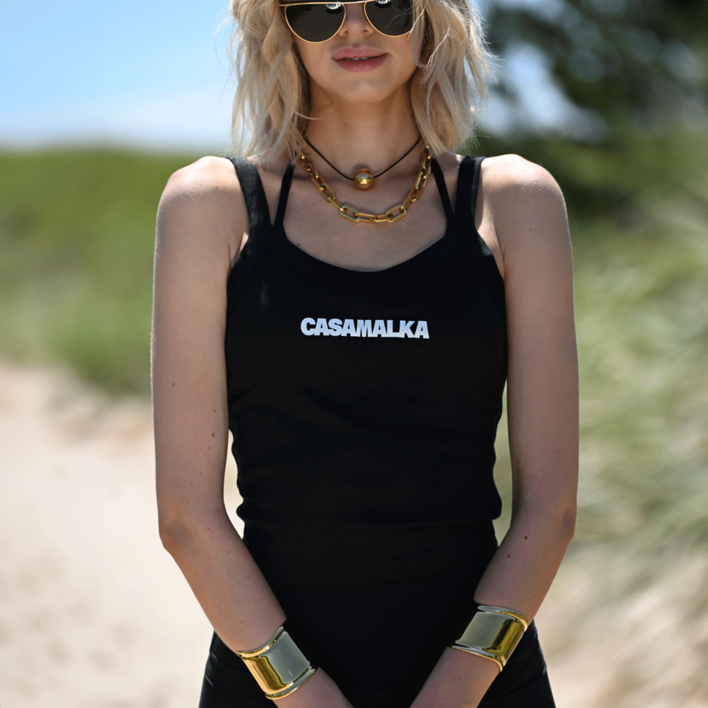 Woman wearing black Casa Malka tank top with logo, front view
